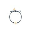 A navy blue cord bracelet with a gold Gemini Link charm by Tory Burch, designed for women's empowerment.