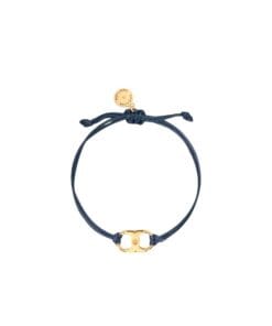 A navy blue cord bracelet with a gold Gemini Link charm by Tory Burch, designed for women's empowerment.