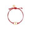 A close-up of the Tory Burch Embrace Ambition Bracelet in Red Gold featuring the 18k-gold plated Gemini Link charm on a red cord.