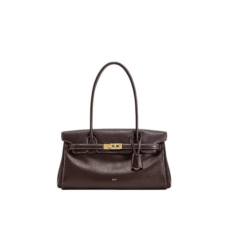 A stylish woman carrying the JW PEI Yara Shoulder Bag in Dark Brown made of vegan leather.
