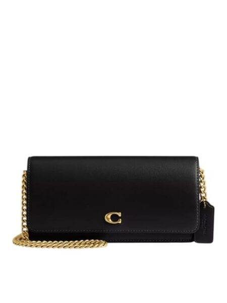 A woman's Coach Evie Long Wallet in black refined calf leather featuring a detachable chain strap and signature hardware.